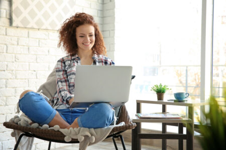 Woman using laptop while sitting in chair