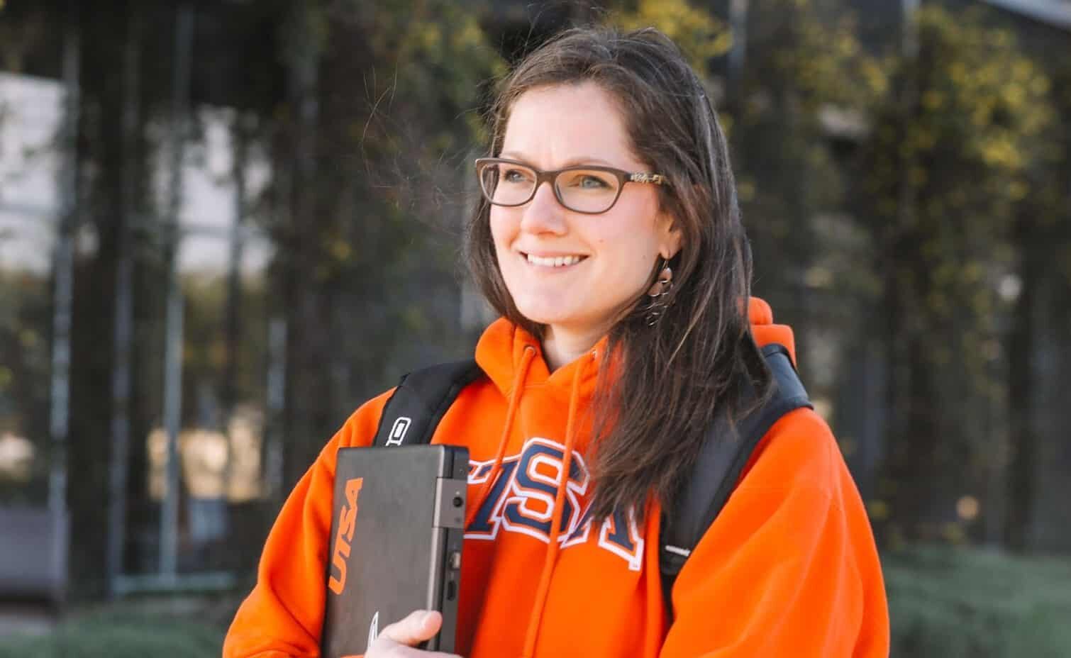 UTSA Online female student in orange UTSA hoodie