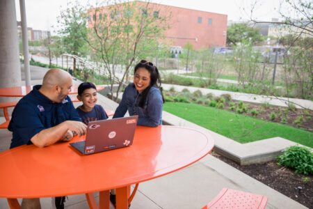 UTSA Online student and his family sitting at a picnic table.