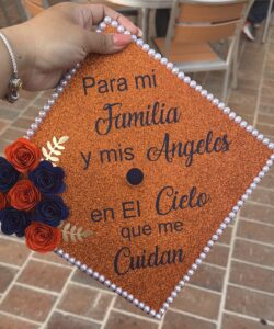 Image of a graduation cap decorated to say "For my family and my angels in Heaven that watch over me."