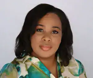 Woman with shoulder-length black hair and a green and cream top.