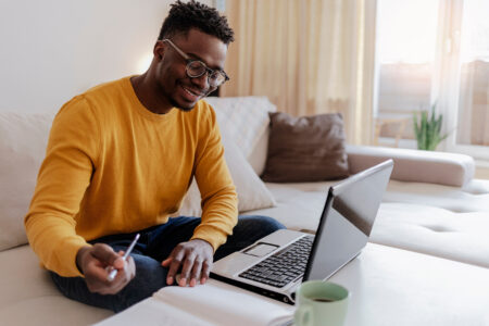 Man working on his laptop while sitting on the couch