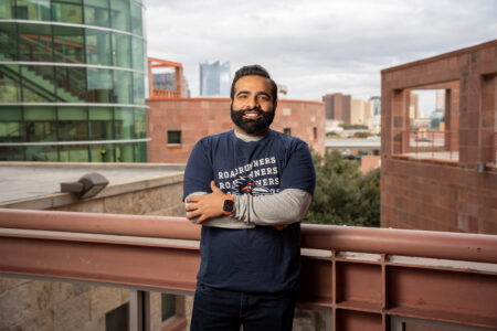 Man standing on balcony with his arms crossed 