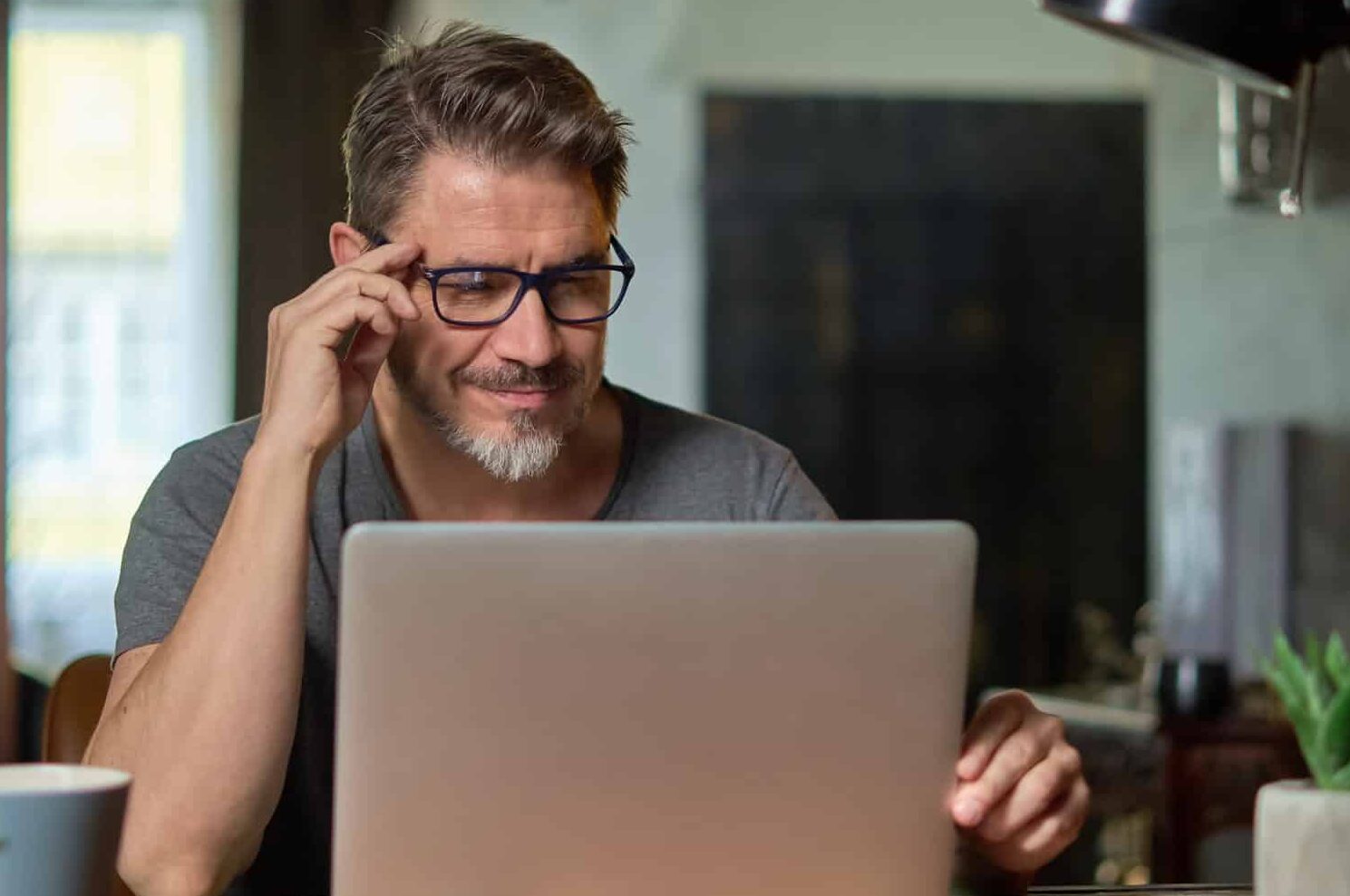Man wearing glasses and working on a computer