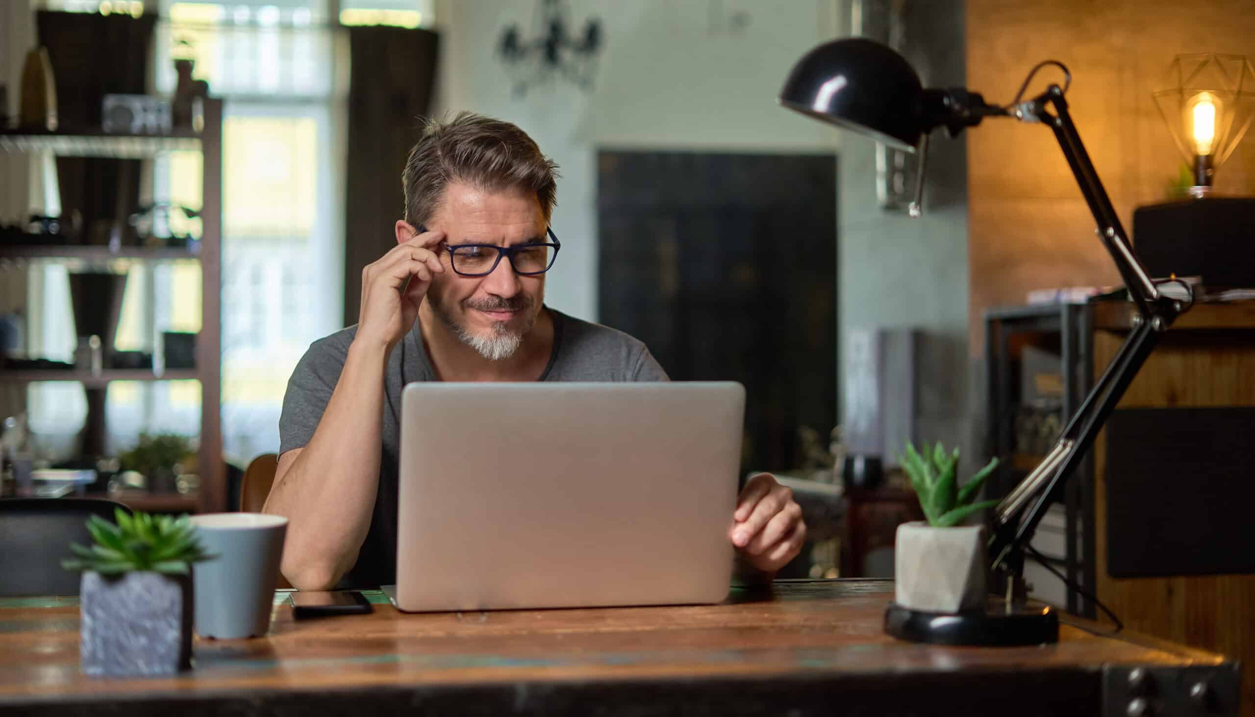 Man wearing glasses and working on a computer