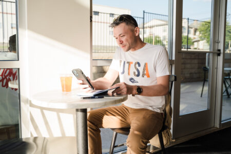 Man looking at phone sitting at a table