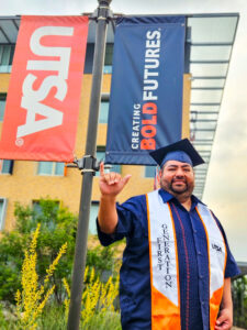 Roger Ruiz doing the "Birds Up" hand signal on campus