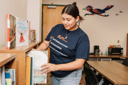 Woman putting book in a bookshelf