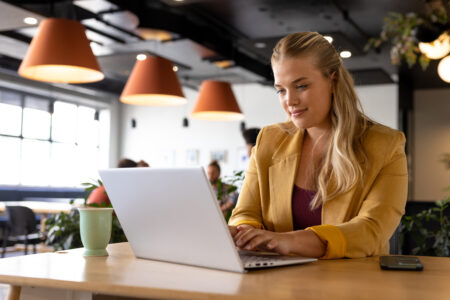 Happy woman working on a computer in a coffee shop