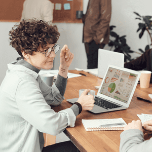 Woman leading a data analytics meeting with two other men.