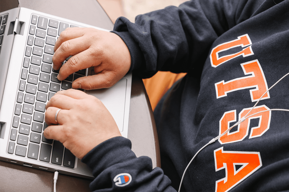 utsa student writing on laptop