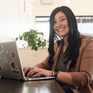 UTSA online cyber security female student working on her laptop