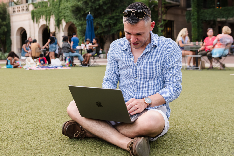 male student with his laptop sitting in a lawn